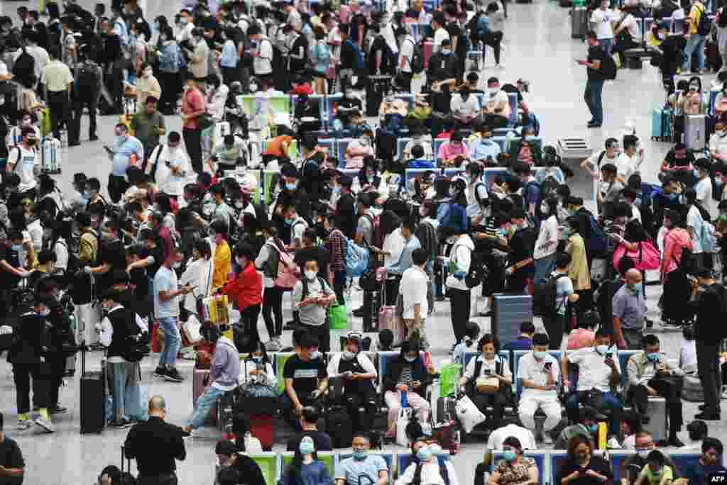 Passengers wait for their trains at Hangzhou East train station, in China's eastern Zhejiang province a day before an eight-day national holiday marking China's National Day and the Mid-Autumn Festival.