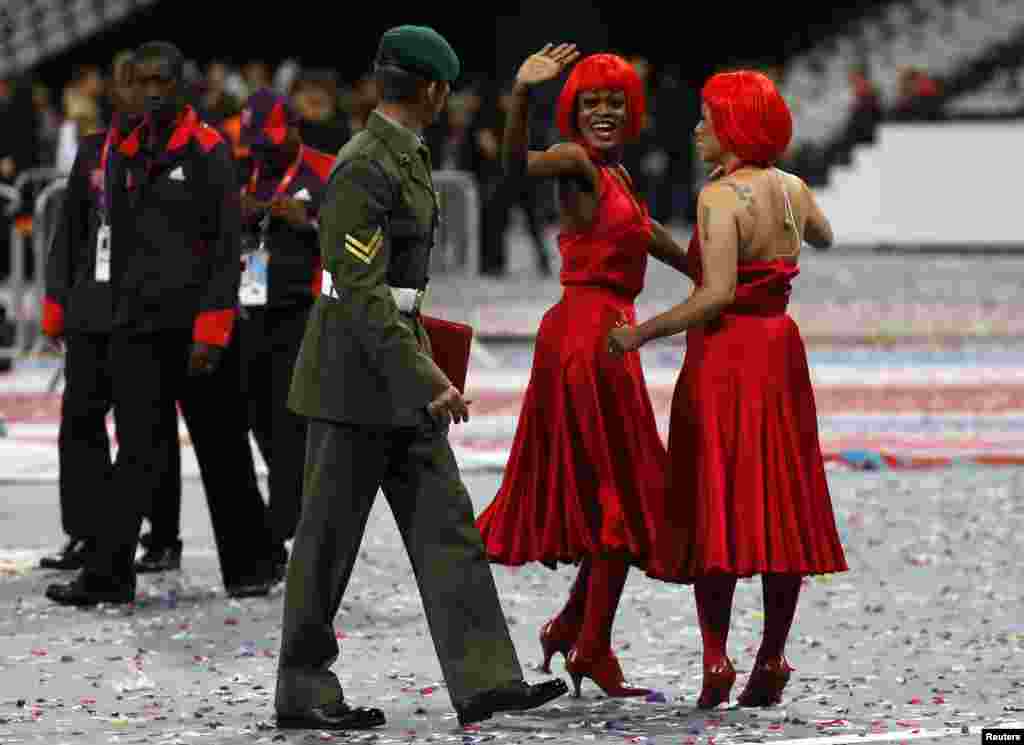Performers say goodbye to their escort after the end of closing ceremony of the London 2012 Olympic Games at the Olympic stadium August 12, 2012.