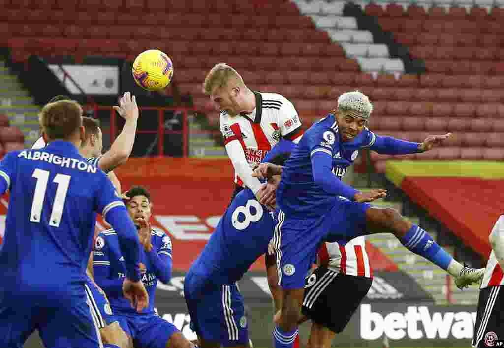 Sheffield United's Oliver McBurnie, top right, scores his side's opening goal during the English Premier League soccer match between Sheffield United and Leicester City, at the Brammall Lane Stadium in Sheffield, England.