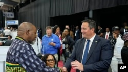 Líder da principal oposição, Aliança Democrática, John Steenhuisen, à direita, aperta a mão ao presidente do ANC, Gwede Mantashe, à esquerda, após as eleições, África do Sul, a 31 de maio de 2024. (AP Photo/Themba Hadebe, Ficheiro)