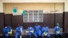 FILE - Health workers rest outside a quarantine zone at a Red Cross facility in the town of Koidu, Kono district in Eastern Sierra Leone, Dec. 19, 2014. 
