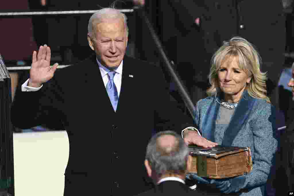 Joe Biden is sworn in as the 46th president of the United States by Chief Justice John Roberts as Jill Biden holds the Bible during the inauguration at the Capitol in Washington, D.C.