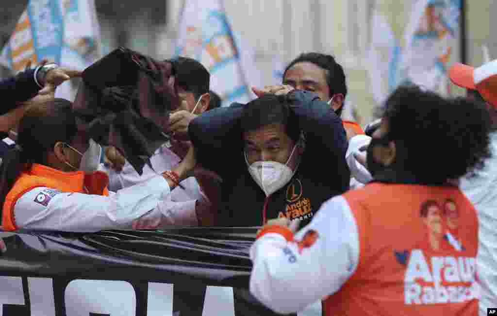Andres Arauz, presidential candidate for the alliance "Unidos por la Esperanza" reacts after being struck in the head by an object during a rally in Quito, Ecuador, Jan. 26, 2021.