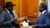 FILE - South Sudan's rebel leader Riek Machar (R) and South Sudan's President Salva Kiir (L) exchange signed peace agreement documents in Addis Ababa, Ethiopia, May 9, 2014.