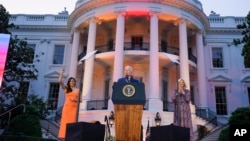 El presidente Joe Biden habla mientras Eva Longoria y la primera dama Jill Biden escuchan antes de la proyección de la película "Flamin' Hot", el jueves 15 de junio de 2023, en el jardín sur de la Casa Blanca en Washington.