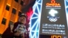 A supporter of the 2022 Beijing Winter Olympics poses for photos with a countdown clock as it crosses into the 100 days countdown to the opening of the Winter Olympics in Beijing, China, Oct. 26, 2021.