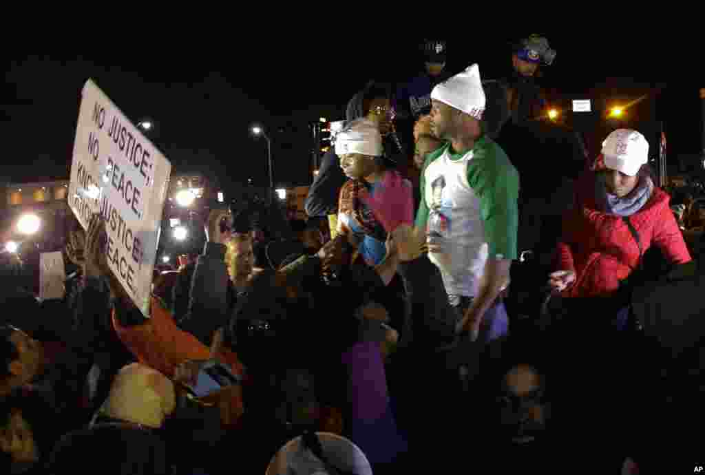 Bà Lesley McSpadden, mẹ của Michael Brown (trái) đứng trên nóc xe khi lắng nghe thông báo về quyết định của bồi thẩm đoàn tại Ferguson, Missouri, ngày 24/11/2014.