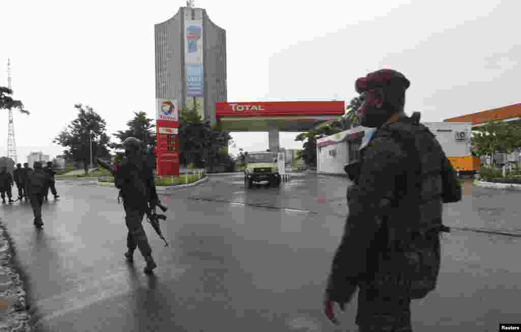 Congolese security forces secure the street near the state television headquarters in Kinshasa, Dec. 30, 2013.