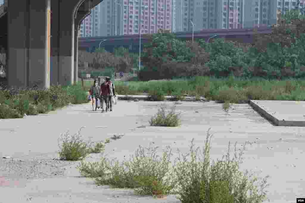 天津爆炸事故現場,核心爆炸區週圍多座居民樓窗戶被震碎,高速公路橋樑受損,多輛大貨車被炸翻,小汽車起火或被砸,多名當地居民仍逗留在事故現場。(美國之音記者東方拍攝)