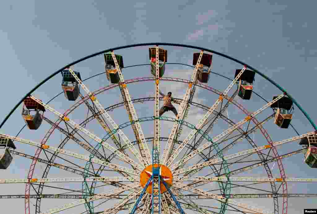 A man inspects a Ferris wheel at a public park in Sardaryab, Charsadda, on the outskirts of Peshawar, Pakistan.