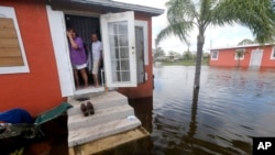 Quintana y Liz Perez observan la inundación frente a su casa en Immokalee, Florida, causada por el huracán Irma, el 11 de septiembre, de 2017.