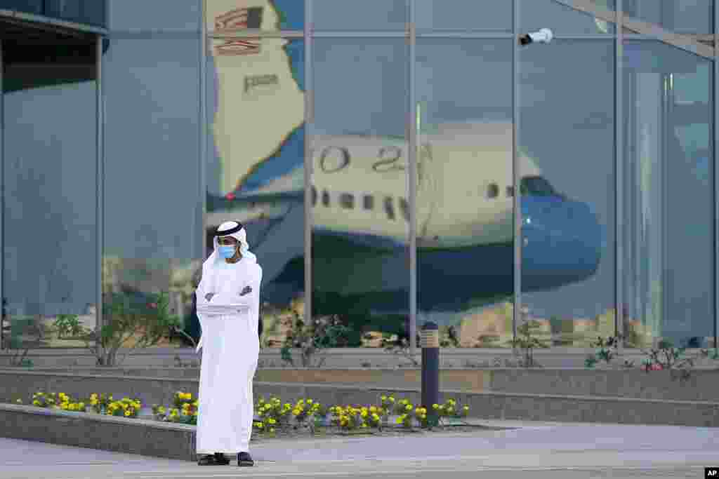 A man stands on a tarmac as Secretary of State Mike Pompeo's plane is reflected in windows at Al Bateen Executive Airport in Abu Dhabi, United Arab Emirates. Pompeo is visiting the United Arab Emirates as part of a trip to Europe and the Middle East.