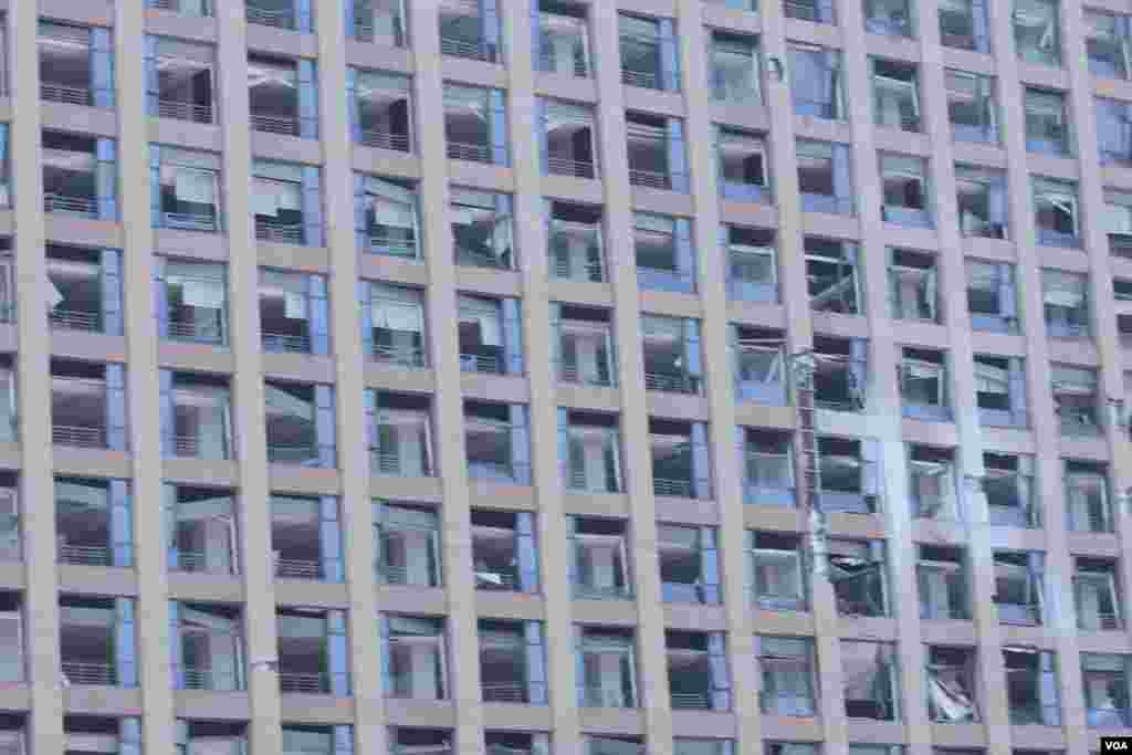 天津爆炸事故現場,核心爆炸區週圍多座居民樓窗戶被震碎,高速公路橋樑受損,多輛大貨車被炸翻,小汽車起火或被砸,多名當地居民仍逗留在事故現場。(美國之音記者東方拍攝)
