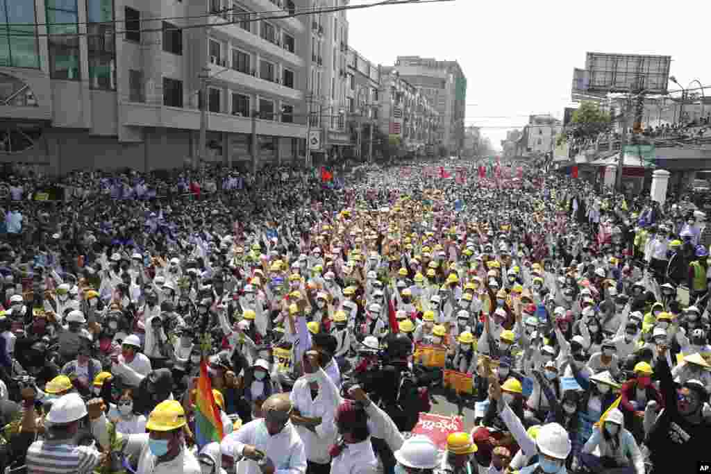 Anti-coup protesters raise their hands with clenched fists during a rally near the Mandalay Railway Station in Mandalay, Myanmar. A call for a general strike by demonstrators protesting the military's seizure of power has been met by the ruling junta with a thinly veiled threat to use lethal force.
