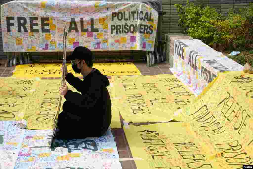 A supporter of pro-democracy activists holds a sign outside West Kowloon Magistrates' Courts where others queue up for a court hearing over charges related to national security, in Hong Kong, China.