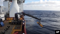 Operadores australianos sacan del mar el minisubmarino con el que se busca el avión desaparecido de Malaysia Airlines.