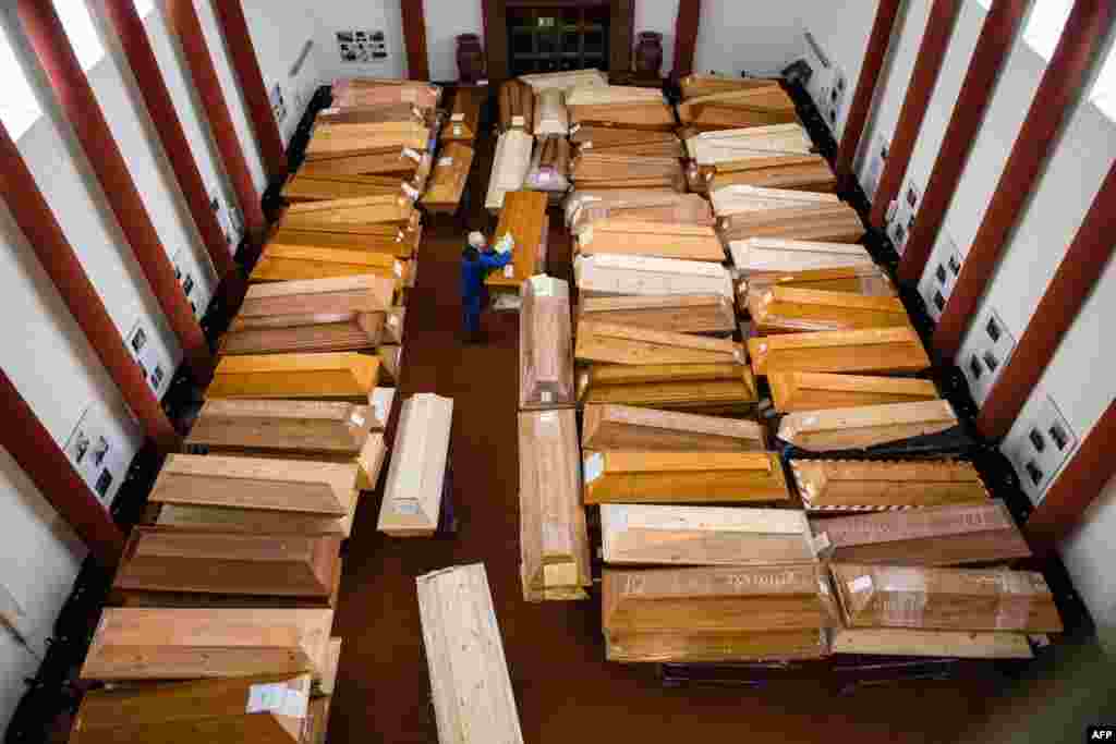 An employee stores coffins in the mourning hall of the crematorium in Meissen, eastern Germany. Most of the deceased, who will be cremated here, have died of or with the coronavirus.