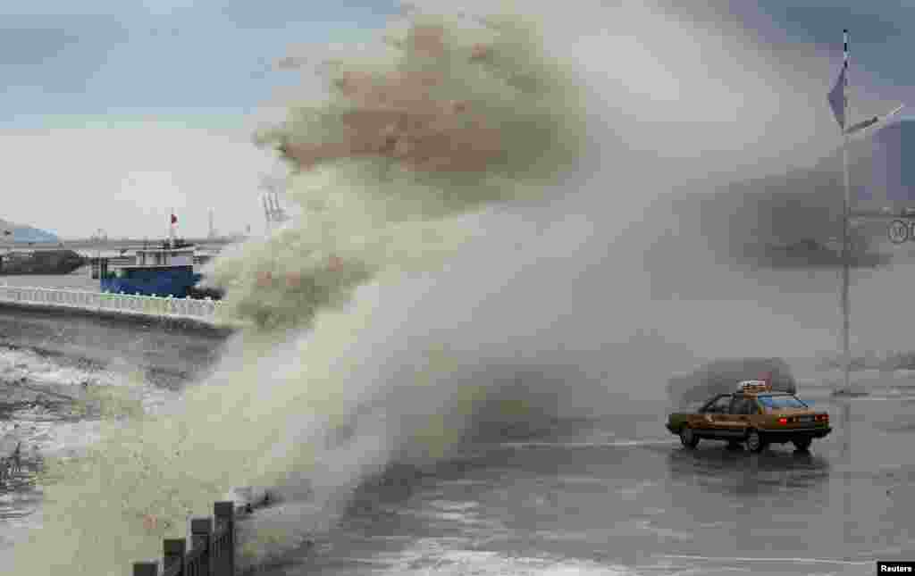 A storm surge under the influence of Typhoon Usagi overtakes vehicles at the coastline in Lianyungang, Jiangsu province, Sept. 24, 2013. 