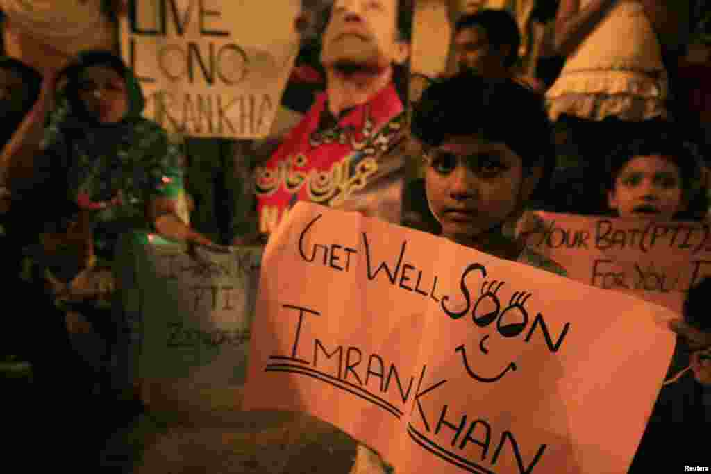 Christian supporters of Imran Khan, Pakistani cricketer-turned-politician and chairman of political party Pakistan Tehreek-e-Insaf, hold placards as they light candles next to a portrait of Khan in Lahore, Pakistan, May 8, 2013.
