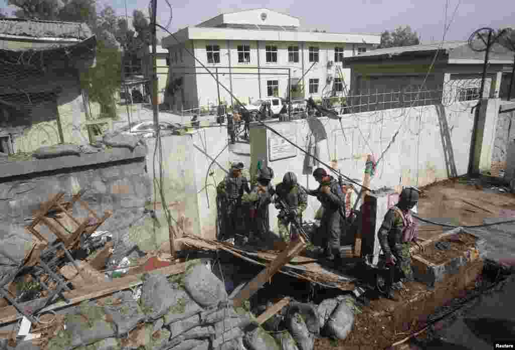 Afghan National Army (ANA) soldiers leave the site of a suicide car bomb attack in Jalalabad province, Afghanistan, March 20, 2014.