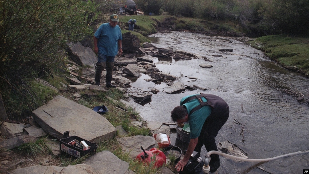FILE - Elden Kinderknetch was looking for gold near Atlantic City, Wyoming on Sept. 13, 1998. The stepping stones made it easier to cross the creek. (AP File Photo)