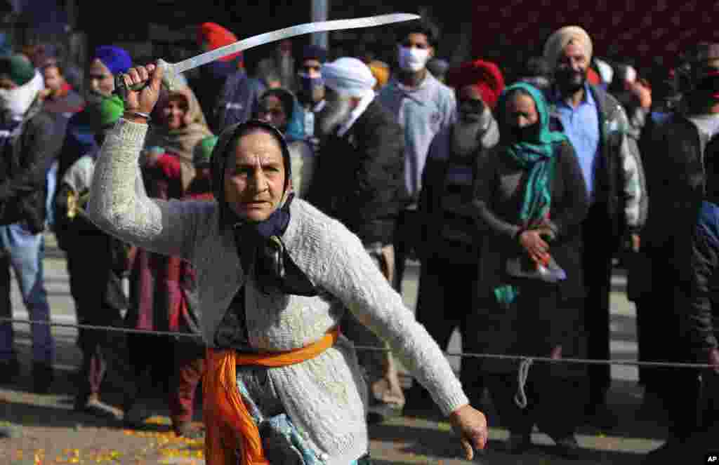 A Sikh woman displays traditional martial art skills during a religious procession ahead of the birth anniversary of Guru Gobind Singh in Jammu, India.