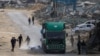Palestinci trče da uzmu boce sa vodom nakon što su ispale iz kamiona koji prevozi humanitarnu pomoć u Gazi (Foto: Eyad BABA / AFP)