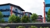 In this Sunday, May 10, 2020, photo, people sit outside a building balcony at the S11@Punggol, a complex of dormitory buildings for foreign workers in Singapore. A second wave of coronavirus infections in tightly packed foreign workers' dormitories…