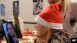 Caterina Bertocchi, 91, talks via video call with Irene Schiavone, a donor unrelated to her, who bought and sent her a Christmas present through an organization dubbed ‘Santa's Grandchildren’, at the Martino Zanchi nursing home in Alzano Lombardo, Italy,