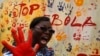 A teacher reacts after marking a canvas following a performance by actors during an awareness campaign against Ebola at Anono school in Abidjan September 25, 2014. REUTERS/Luc Gnago (IVORY COAST - Tags: HEALTH EDUCATION) - RTR47QF7
