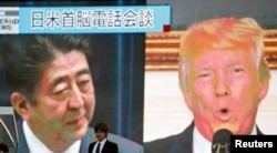 Čovek prolazi ulicom pored ekrana na kome se prikazuje vest o telefonskom razgovoru japanskom premijera Šinzoa Abea i predsednika SAD Donalda Trampa, u Tokiju, 3. septembra 2017.