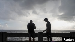  Alex Rodríguez y su primo Javier Rodríguez pescan desde el muelle del puente North Skyway mientras nubes oscuras se ciernen sobre el canal de la Bahía de Tampa antes de la tormenta tropical Elsa, en St. Petersburg, Florida, el 5 de julio de 2021. REUTERS