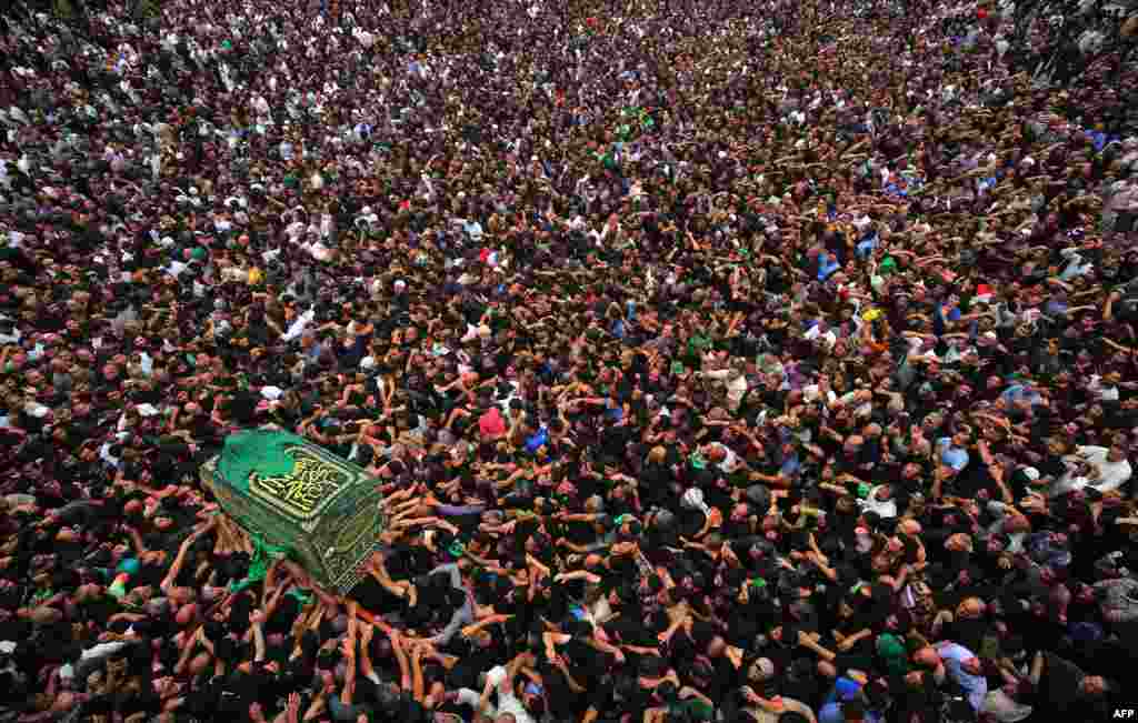 Shiite Muslim worshipers carry a symbolic casket as they gather at the Imam Musa al-Kadhim's mosque in the Iraqi capital’s northern district of Kadhimiya on April 12, 2018 as they mark the anniversary of the Imam's death in the 8th century.