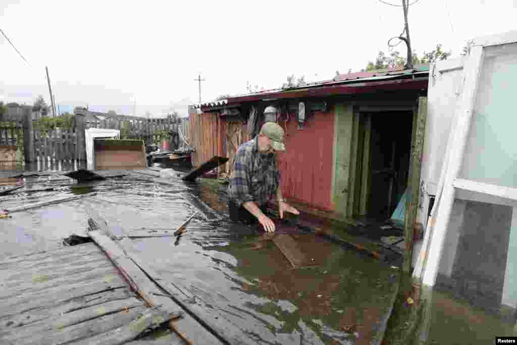 A man wades through a flooded garden in a village outside Komosomolsk-on-Amur in Russia's far eastern Khabarovsk region.