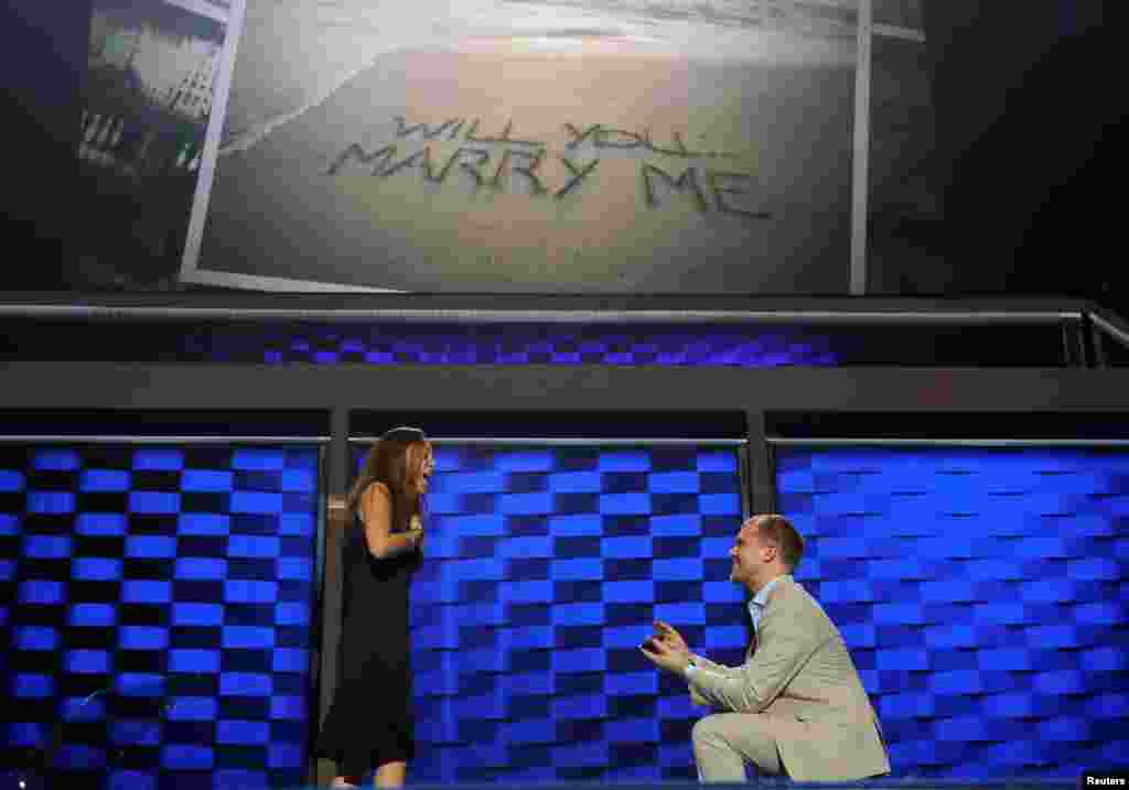 Hillary Clinton campaign staffer Liz Hart (L) reacts as fellow campaign staffer Andrew Binns proposes on stage at the Wells Fargo Center the day before the Democratic National Convention in Philadelphia, Pennsylvania, July 24, 2016.