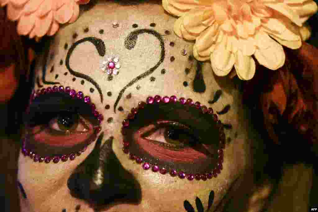 A woman dressed as La Calavera Catrina takes part in a "Moto-Halloween party" along the streets in Cali, Colombia, Oct. 29, 2016.
