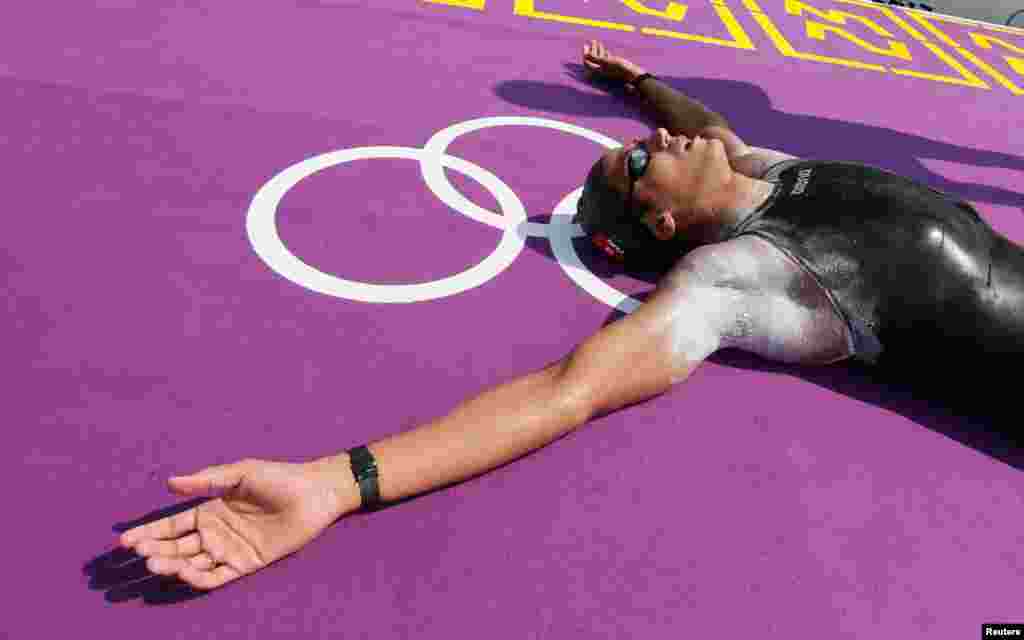 Oussama Mellouli của Tunisia nằm lăn ra sân sau khi giành huy chương vàng môn bơi marathon 10 km nam. REUTERS/Stefan Wermuth