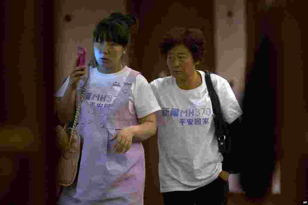 Keluarga penumpang China penerbangan MH370 yang hilang meninggalkan ruangan rapat di sebuah hotel di Beijing, 23 Maret 2014.