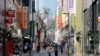 Women, wearing masks to prevent contracting COVID-19 following the outbreak of the coronavirus disease, walk in a shopping district in Seoul, South Korea, March 23, 2020.