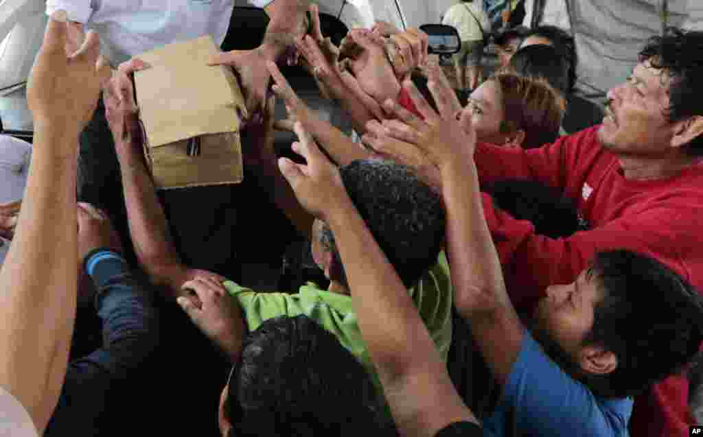 A person distributes food to hurricane victims under a bridge in San Pedro Sula, Honduras, Nov. 21, 2020.