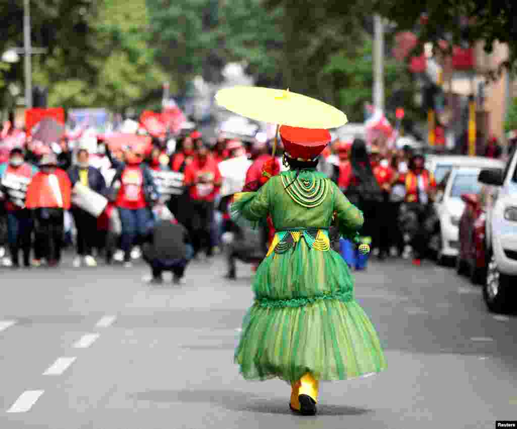 A Member of the Congress of South African Trade Unions (COSATU) joins others as they take part in a nationwide strike over issues including corruption and job losses, outside parliament in Johannesburg.