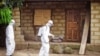 In this file photo taken on Tuesday, Oct. 21, 2014, a healthcare worker in protective gear sprays disinfectant around the house of a person suspected to have the Ebola virus in Port Loko Community, situated on the outskirts of Freetown, Sierra Leone. (AP