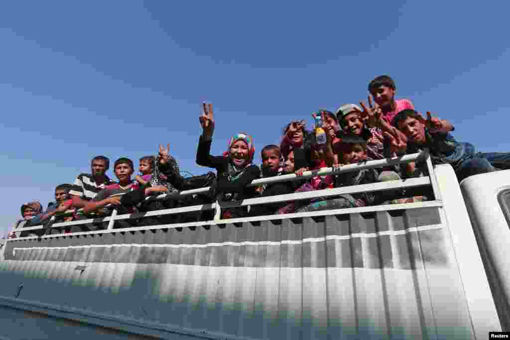 Warga sipil di atas truk pickup setelah mereka dievakuasi oleh pasukan pemberontak Suriah di Manbij, Aleppo (12/8). (Reuters/Rodi Said)