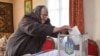 A local resident casts a vote into a mobile ballot box inside a house during a presidential election in the village of Zahiria in Lviv Region, Ukraine, March 31, 2019. 