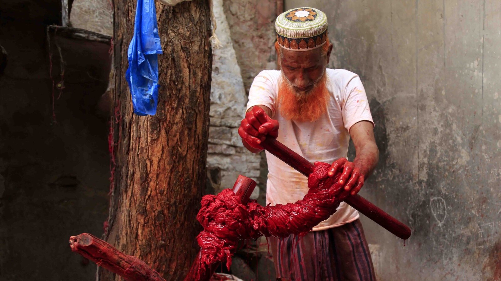 An Indian Muslim worker applies colors on Kalavas (sacred threads) in Ajmer in the Indian state of Rajasthan.