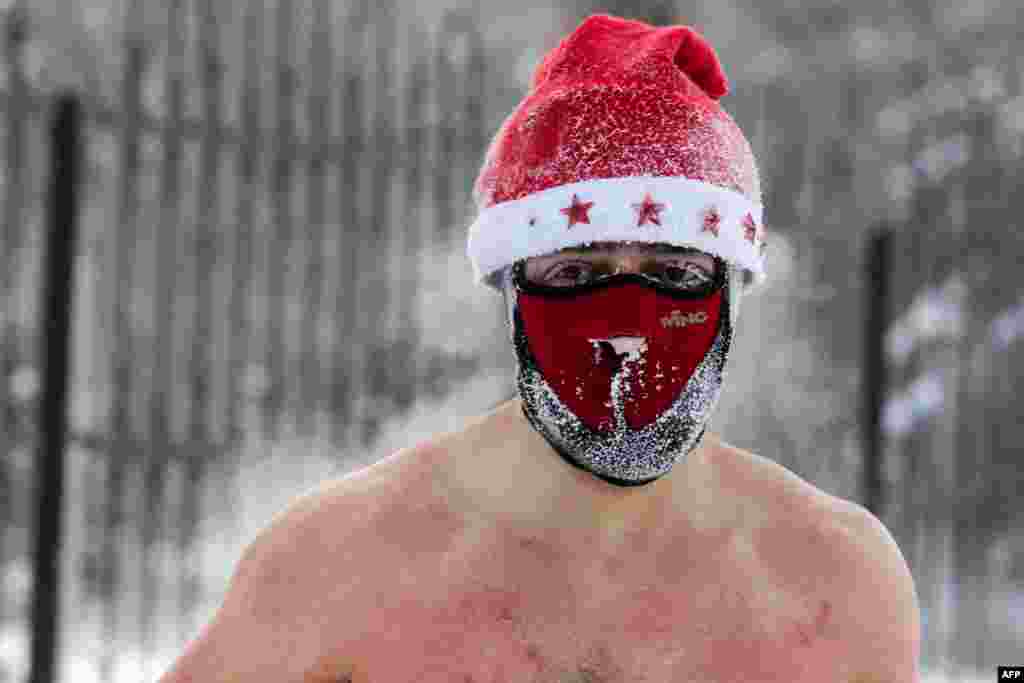 A member of the ice swimming club prepares to swim in the icy water as the temperature drops down to -34°C (-29°F), in the Siberian city of Novosibirsk, Russia, Dec. 26, 2020.