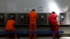 Inmigrantes detenidos en un centro en Adelanto, California, usan los teléfonos públicos mientras defensores de los inmigrantes abogan por su liberación.