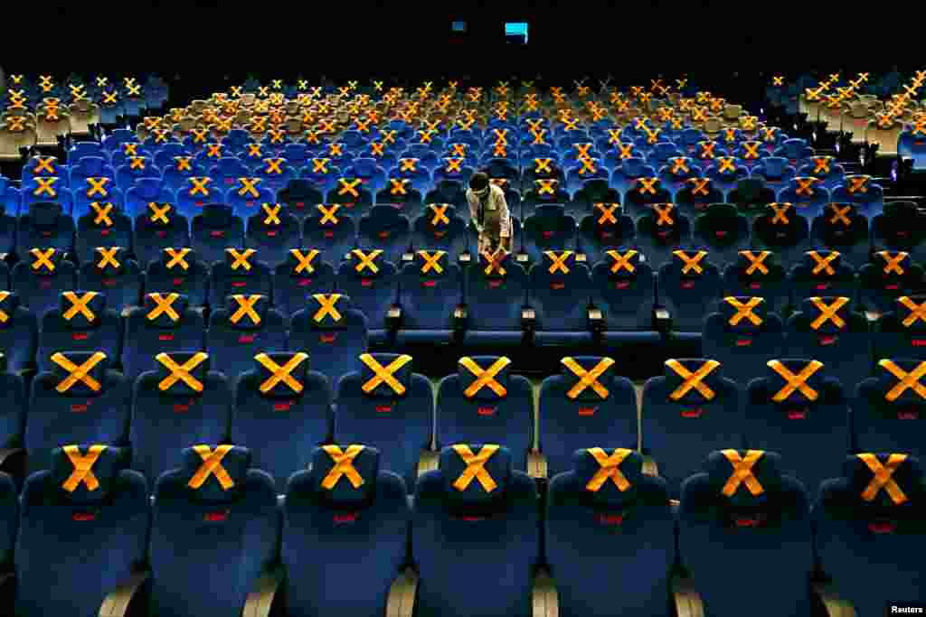 Staff member marks seats for social distancing at a movie theater at CGV cinema amid the COVID-19 pandemic in Jakarta, Indonesia.