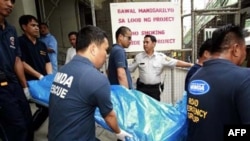 Nhân viên cứu hộ khiêng xác các nạn nhân ra khỏi công trình xây dựng nhà cao tầng ở Manila, ngày 27/1/2011