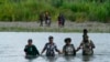 Migrantes haitianos vadean el río Tuquesa después de caminar por el Tapón del Darién, el miércoles 4 de octubre de 2023, en Bajo Chiquito, Panamá. 